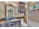 A full bathroom with a tub and shower combo, dark cabinets, and a large mirror at 416 Casey Key Rd, Nokomis, FL 34275