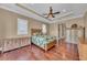 Inviting bedroom featuring tray ceilings, hardwood floors, and a relaxing tropical theme at 416 Casey Key Rd, Nokomis, FL 34275