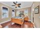 Bedroom with hardwood floors, three windows, and a ceiling fan at 416 Casey Key Rd, Nokomis, FL 34275