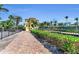 Stunning yellow home features a garden and black metal fence along a brick driveway at 416 Casey Key Rd, Nokomis, FL 34275