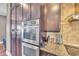 This kitchen has stainless steel appliances, granite countertops, and dark wood cabinets at 416 Casey Key Rd, Nokomis, FL 34275
