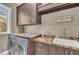 Well-equipped laundry room featuring modern appliances, granite countertops, and ample storage for convenience at 416 Casey Key Rd, Nokomis, FL 34275