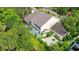An aerial view of a cream-colored home surrounded by lush greenery and a quaint patio area at 4326 Brackenwood Ct, Sarasota, FL 34232