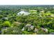 Aerial view of a home nestled among lush trees near a serene lake and a nearby highway at 4326 Brackenwood Ct, Sarasota, FL 34232