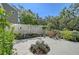 Large, private fenced-in backyard space with a center flower bed surrounded by foliage and potted plants at 4326 Brackenwood Ct, Sarasota, FL 34232
