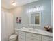 Bright bathroom features white vanity, drawers, crystal hardware, and decorative lighting above the sink at 4326 Brackenwood Ct, Sarasota, FL 34232