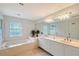 Spacious bathroom with a jacuzzi tub, double sinks, large mirror and natural light from large windows at 4326 Brackenwood Ct, Sarasota, FL 34232