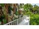Inviting side view of a home with a charming walkway bordered by lush landscaping and vibrant tropical plants at 4326 Brackenwood Ct, Sarasota, FL 34232