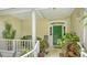 Inviting front porch with rocking chairs, potted plants, and a decorative green door at 4326 Brackenwood Ct, Sarasota, FL 34232