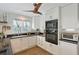 Bright modern kitchen featuring white cabinetry, black countertops and modern appliances at 4326 Brackenwood Ct, Sarasota, FL 34232
