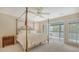 Bedroom with a canopy bed, neutral carpet, chest of drawers, and access to a screened porch at 4326 Brackenwood Ct, Sarasota, FL 34232
