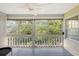 Enclosed porch featuring a ceiling fan, wood railings, and views of the surrounding foliage at 4326 Brackenwood Ct, Sarasota, FL 34232