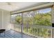 Enclosed porch featuring a ceiling fan, wood railings, and views of the surrounding foliage at 4326 Brackenwood Ct, Sarasota, FL 34232