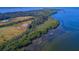 Breathtaking aerial view of a lush island coastline where forest meets the tranquil blue waters at 4517 Pinfish Ln, Palmetto, FL 34221