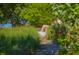 Secluded beach access framed by lush foliage with a sign indicating no cooking fires allowed at 4517 Pinfish Ln, Palmetto, FL 34221