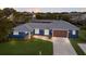 Stunning waterfront home featuring a blue exterior, metal roof, and well-manicured lawn with a private dock at 4517 Pinfish Ln, Palmetto, FL 34221
