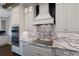 Gourmet kitchen with stainless steel appliances, granite counters, a cooktop and stylish backsplash at 4517 Pinfish Ln, Palmetto, FL 34221
