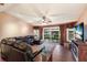 Cozy living room with leather seating, wood-look floors, and sliding glass doors to the backyard at 4517 Pinfish Ln, Palmetto, FL 34221