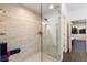 Walk-in shower with glass door, bench, and decorative tiles, complemented by natural light from a nearby window at 4517 Pinfish Ln, Palmetto, FL 34221