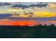 Vibrant sunset casting a fiery glow over a lush green landscape, creating a serene atmosphere at 4517 Pinfish Ln, Palmetto, FL 34221