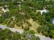 An aerial view of a lushly landscaped property showcasing mature trees and the house nestled within the foliage at 4917 Hidden Oaks Trl, Sarasota, FL 34232