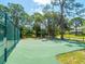 Community basketball court on a sunny day, surrounded by trees at 4917 Hidden Oaks Trl, Sarasota, FL 34232