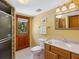 Bathroom featuring a shower, toilet, and vanity with wood cabinets and access to the backyard at 4917 Hidden Oaks Trl, Sarasota, FL 34232