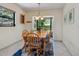 Bright breakfast nook features a wood table, blue cushions, and a large window with a view at 4917 Hidden Oaks Trl, Sarasota, FL 34232