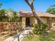 Charming home featuring a stone facade, mature landscaping, and a welcoming brick pathway leading to the front entrance at 4917 Hidden Oaks Trl, Sarasota, FL 34232