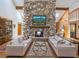 Bright and airy living room featuring a stone fireplace, exposed wood beams, and comfortable seating areas at 4917 Hidden Oaks Trl, Sarasota, FL 34232