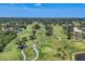 Scenic aerial view of a lush green golf course with ponds and trees, offering a serene landscape at 4947 Greencroft Rd # 175, Sarasota, FL 34235