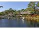 Scenic community view of a pond, clubhouse, and golf carts surrounded by nature at 4947 Greencroft Rd # 175, Sarasota, FL 34235