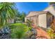 Landscaped front yard showcases a brick pathway and tropical plants leading to the side door at 4947 Greencroft Rd # 175, Sarasota, FL 34235
