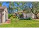Landscaped front yard features lush green lawn, tropical plants, and a brick walkway to the front entrance at 4947 Greencroft Rd # 175, Sarasota, FL 34235