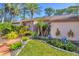 Well-maintained front yard displays tropical landscaping, including palm trees and agave plants, with a brick walkway at 4947 Greencroft Rd # 175, Sarasota, FL 34235