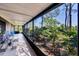 Bright, sunlit screened patio overlooking a verdant landscape with tropical plants at 4947 Greencroft Rd # 175, Sarasota, FL 34235