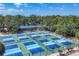 Aerial view of well-maintained pickleball courts surrounded by lush greenery at 4947 Greencroft Rd # 175, Sarasota, FL 34235