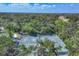 Aerial view of beautiful tennis courts nestled among mature trees at 4947 Greencroft Rd # 175, Sarasota, FL 34235