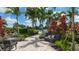 Community pool area with lounge seating, lush plants, palm trees, and a walkway at 5424 Cicerone St # 204, Sarasota, FL 34238