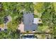 Aerial shot showcasing the roof, patio, landscaping, putting green, driveway, and verdant surroundings of the property at 5504 Beneva Woods Circle, Sarasota, FL 34233
