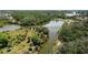 An aerial view showcases a winding waterway and lush tropical trees nestled within established community homesites at 5504 Beneva Woods Circle, Sarasota, FL 34233