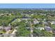Panoramic aerial view showcasing the community's lush canopy, private lake, and an array of elegant homes at 5504 Beneva Woods Circle, Sarasota, FL 34233