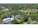 High aerial view showcasing the home, pool, surrounding neighborhood, mature trees, and a nearby pond at 5504 Beneva Woods Circle, Sarasota, FL 34233