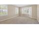 Bedroom featuring neutral carpet and walls, a bay window, and two additional windows at 5504 Beneva Woods Circle, Sarasota, FL 34233