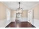 Open concept dining room featuring a modern chandelier, hardwood floors and paneled walls at 5504 Beneva Woods Circle, Sarasota, FL 34233