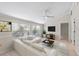 Bright living room features a large white couch, a ceiling fan, neutral walls and trim, and lots of light at 5504 Beneva Woods Circle, Sarasota, FL 34233