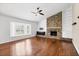 Living room featuring a brick fireplace, wood floors, and a bright bay window at 5504 Beneva Woods Circle, Sarasota, FL 34233