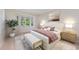 Beautiful main bedroom features a large window, neutral walls, stylish furniture, and bright, natural light at 5504 Beneva Woods Circle, Sarasota, FL 34233