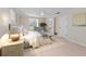 This main bedroom features neutral walls, carpeted floors, white trim, an ensuite, and an accent chair at 5504 Beneva Woods Circle, Sarasota, FL 34233