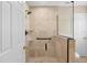 Updated bathroom features a large glass-enclosed walk-in shower with travertine tile and bronze fixtures at 5504 Beneva Woods Circle, Sarasota, FL 34233